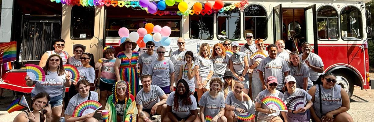 Defenders dressed for the Chicago Pride Parade posing in front of trolley.