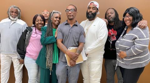 A group of eight Roseland community members, men and women, stand together after a Freedom Defense Center of Roseland planning session.